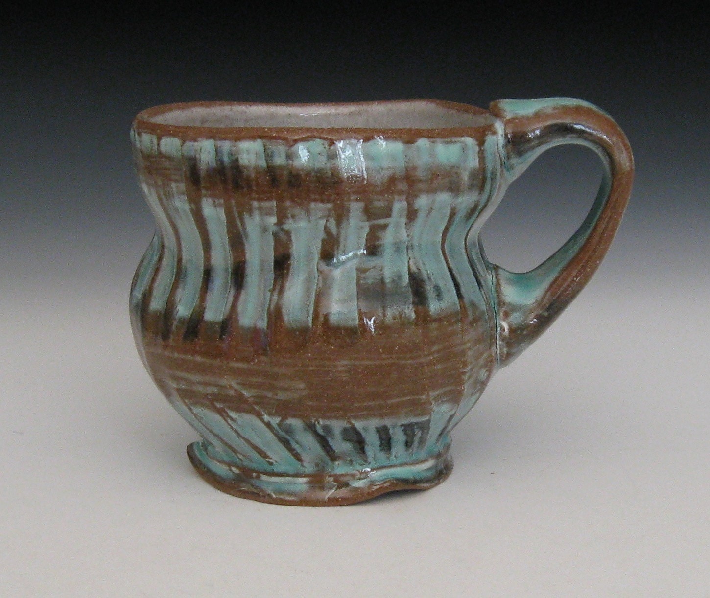green brown and black terra cotta mug