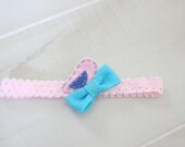 Pink lace elastic headband with a blue felt bow and handstitched pink bird