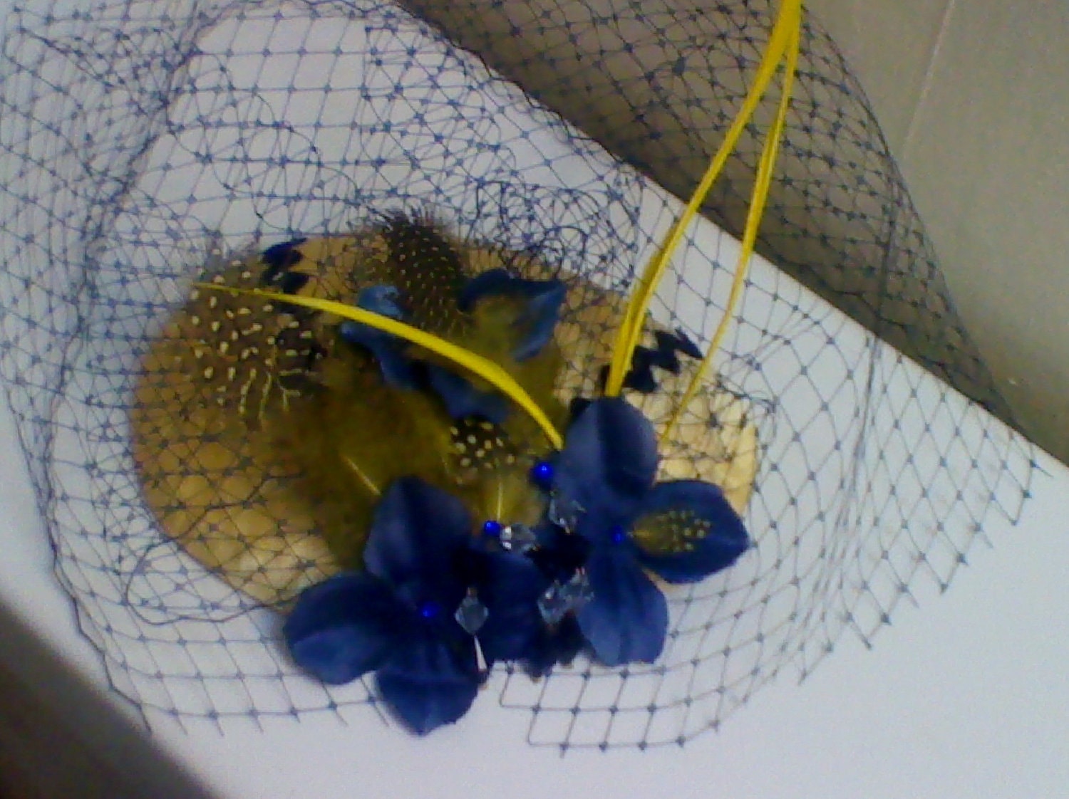 Banana Yellow & dark blue stripe teardrop fascinator, navy blue bird cage veiling accent with yellow feathers and hydrangea petals