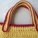 Crocheted tote bag of red and yellow cotton yarn with yellow button accents
