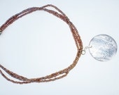 Three strand glass seed beads with a shell pendant