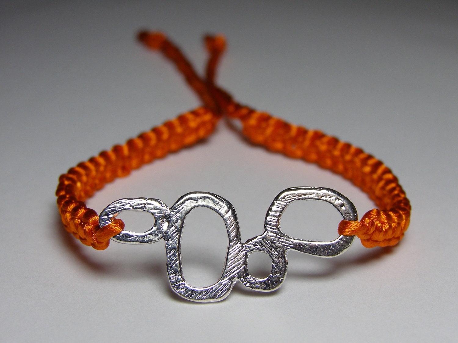 Orange satin bracelet with silvery finding