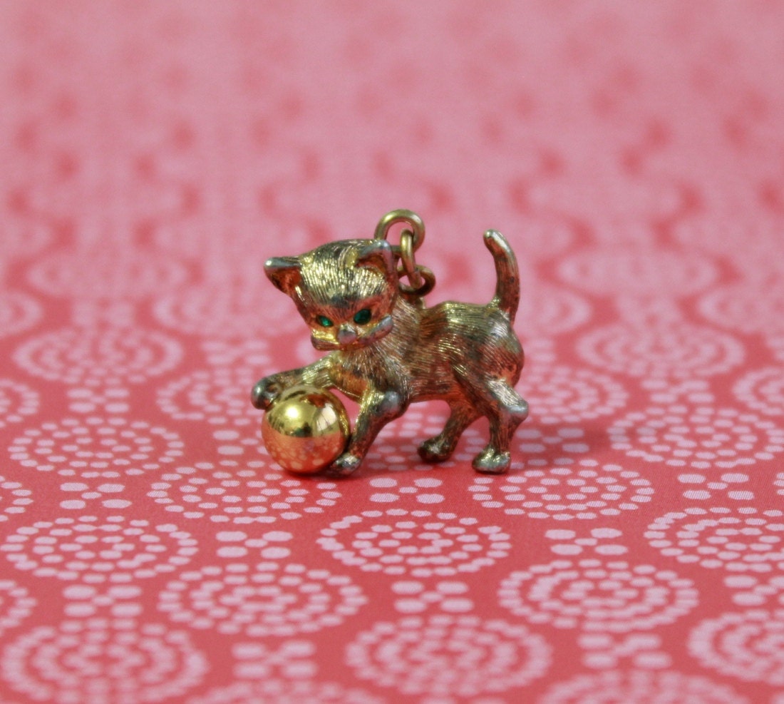 Golden kitten charm - playing with a ball