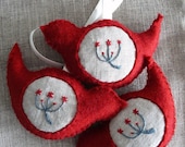 Red bird in eco felt with embroidered flowers on linen.