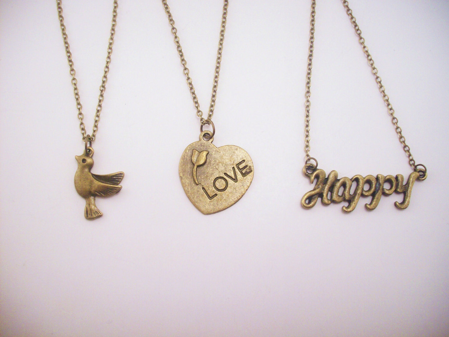 Set of three friendship necklaces. Peace, love, happiness. Brass, gold toned. Dove. Heart with flower. Best friend gift.