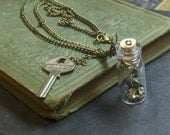 FINDERS KEEPERS. Miniature bottle of pyrite and key necklace.