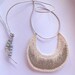 Crescent shaped pendant necklace embroidered with gray beads on silver leather cord