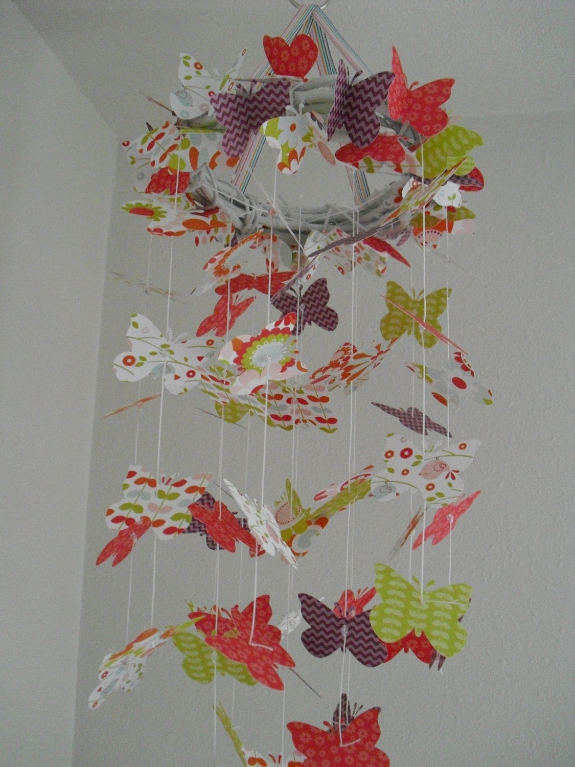 Butterfly Chandelier Mobile in bright pink/red, green, and purple patterns.
