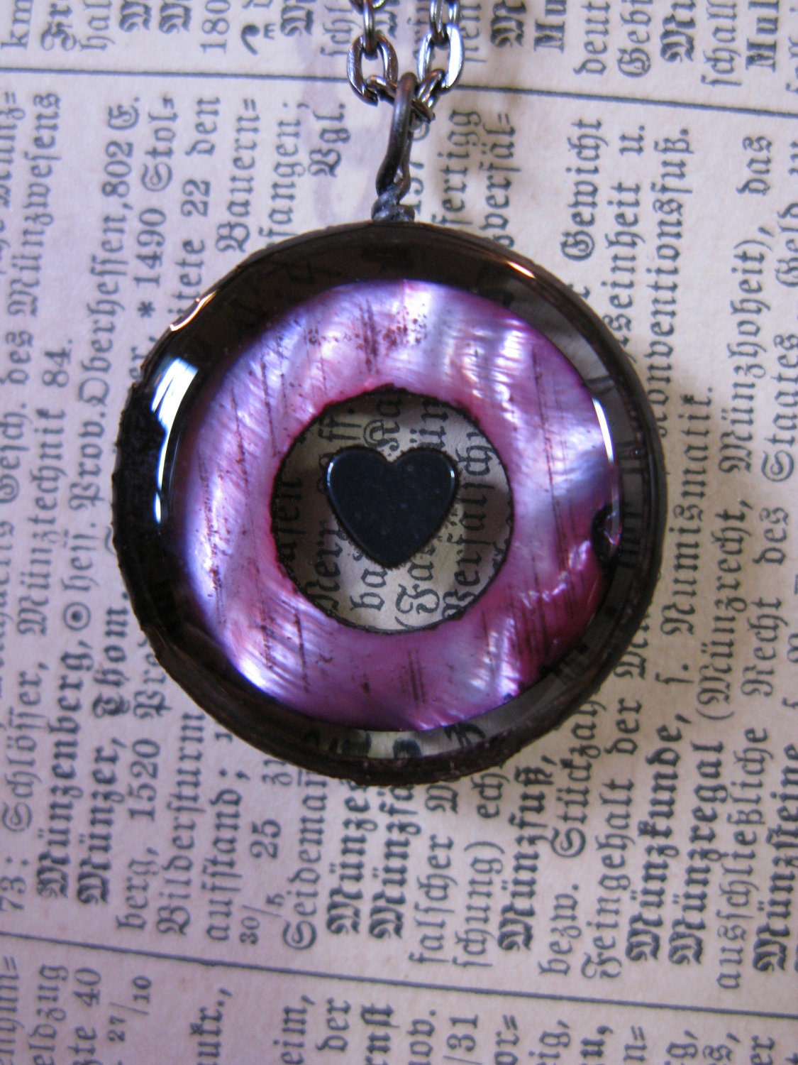 Pretty Pink and Black Pendant - circle bead and heart bead encased in resin with open back black copper bezel
