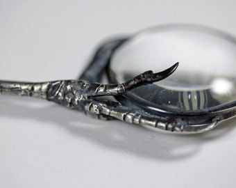 the oracle. magnifying glass and starling claw necklace.