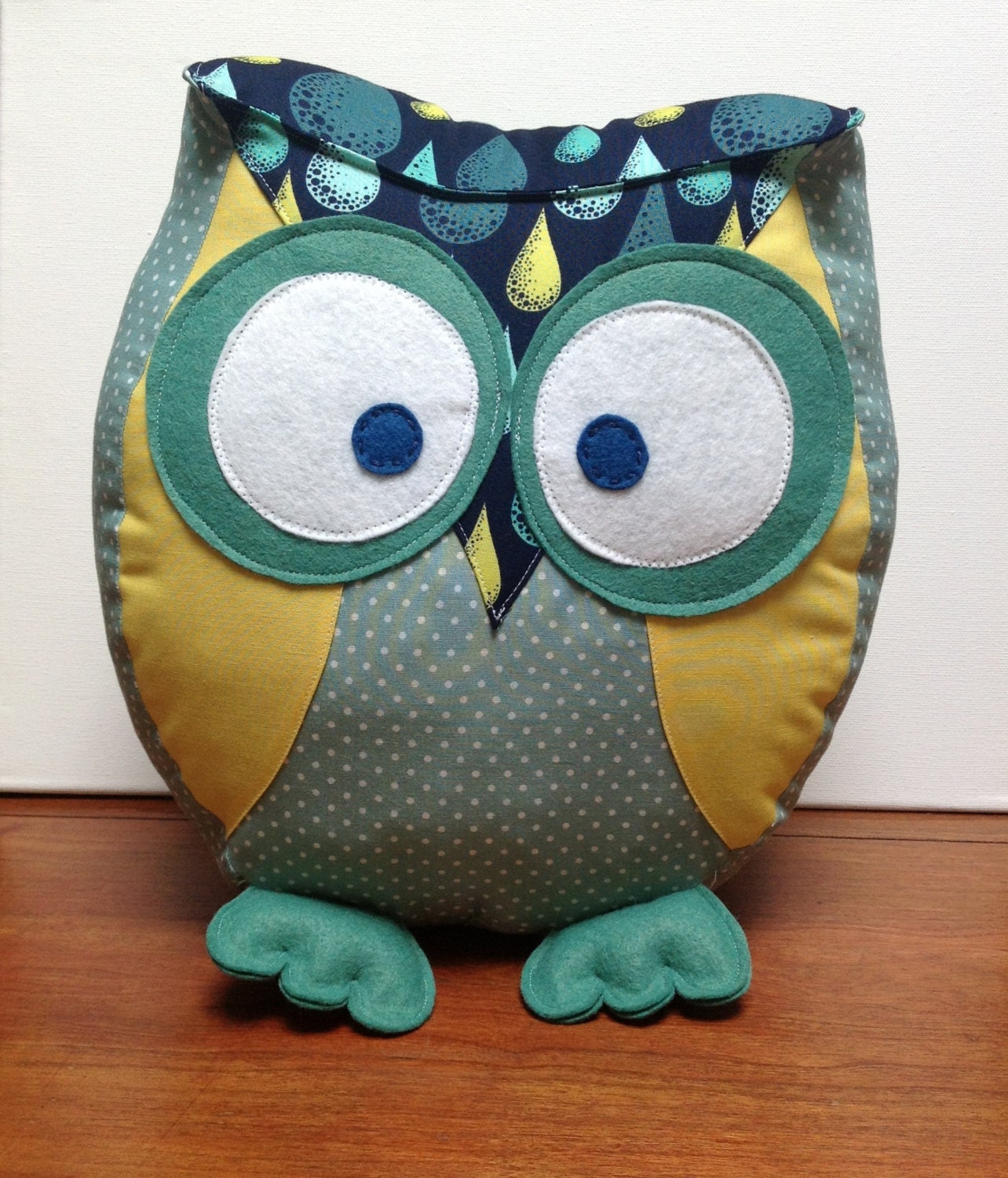 Chubby owl pillow in shades of green, yellow and navy.