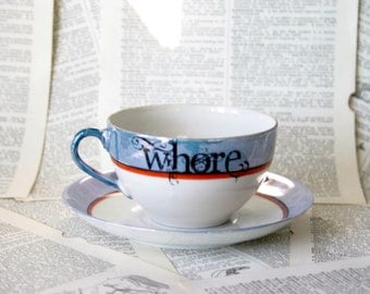 Orange and blue WHORE teacup and saucer set