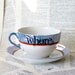 Orange and blue WHORE teacup and saucer set