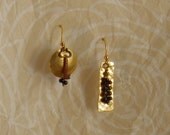 Mismatched pierced earrings in brass.