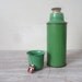 Old thermos in vintage green kitchenalia/ props/ rustic vase