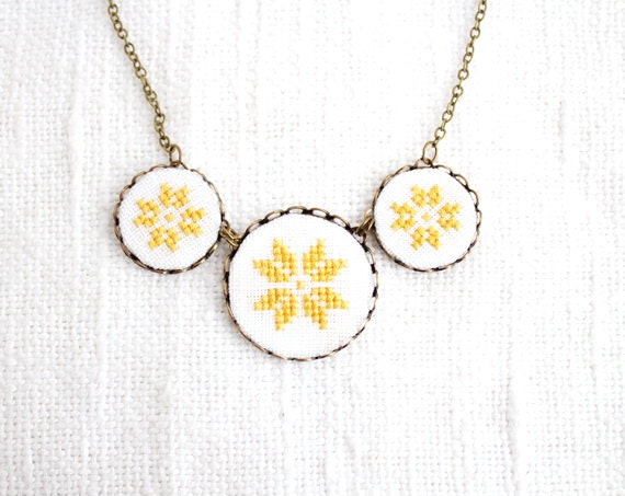 Cross stitch necklace with three yellow ethnic ornament in bronze