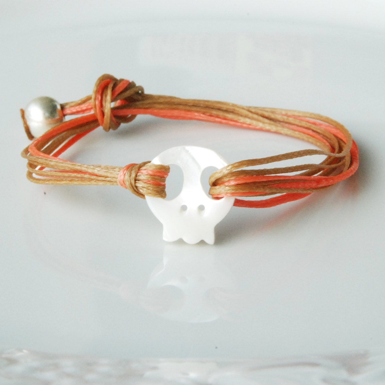Layered skull bracelet on waxed pink and beige cord