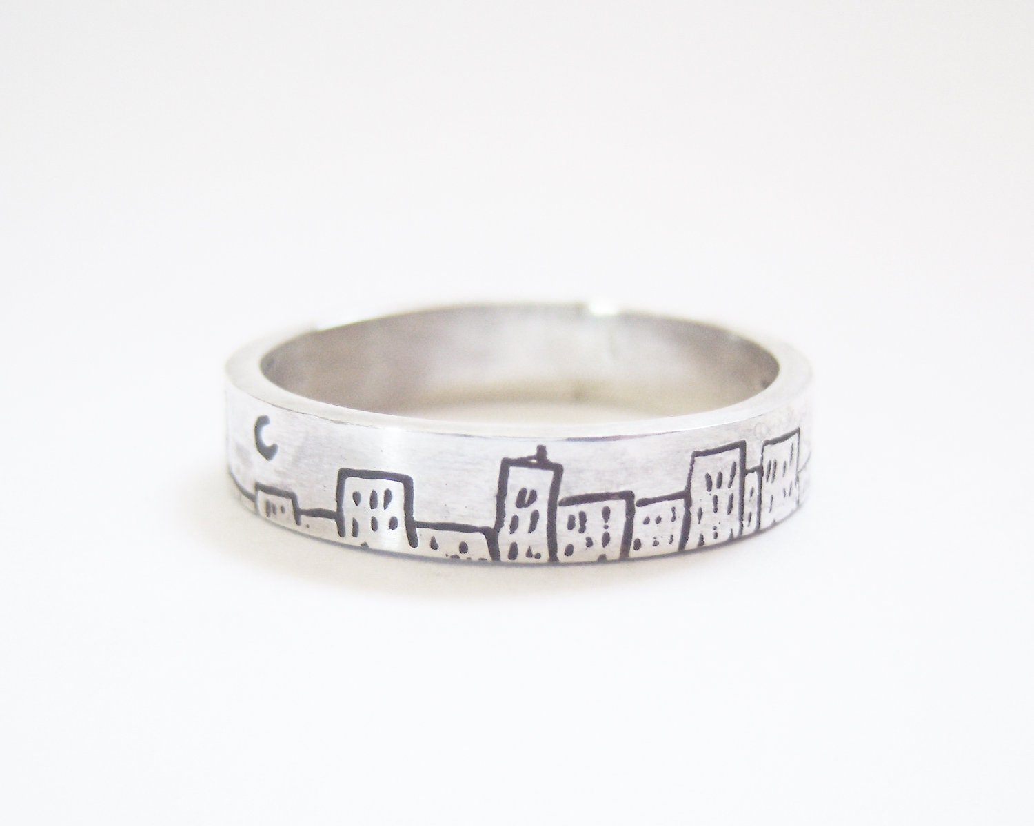 Batman inspired silver ring with The Dark Knight inscription and cityscape etched pattern on the outside