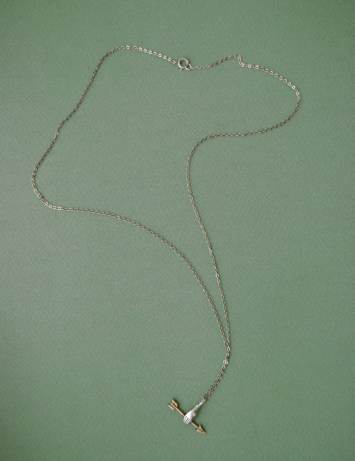 Hand with golden arrow necklace