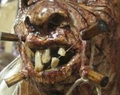 Replica shrunken head detailed sculpture with real pigs teeth, sheep spine & bird plume