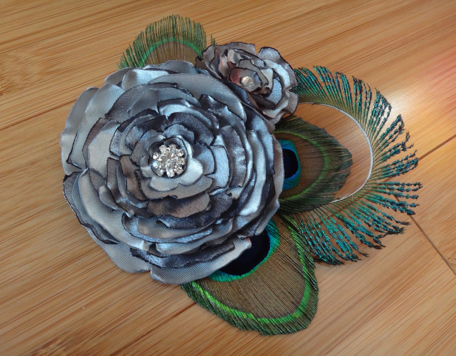 Bridal satin flower hair piece with peacock feathers, available in more colors
