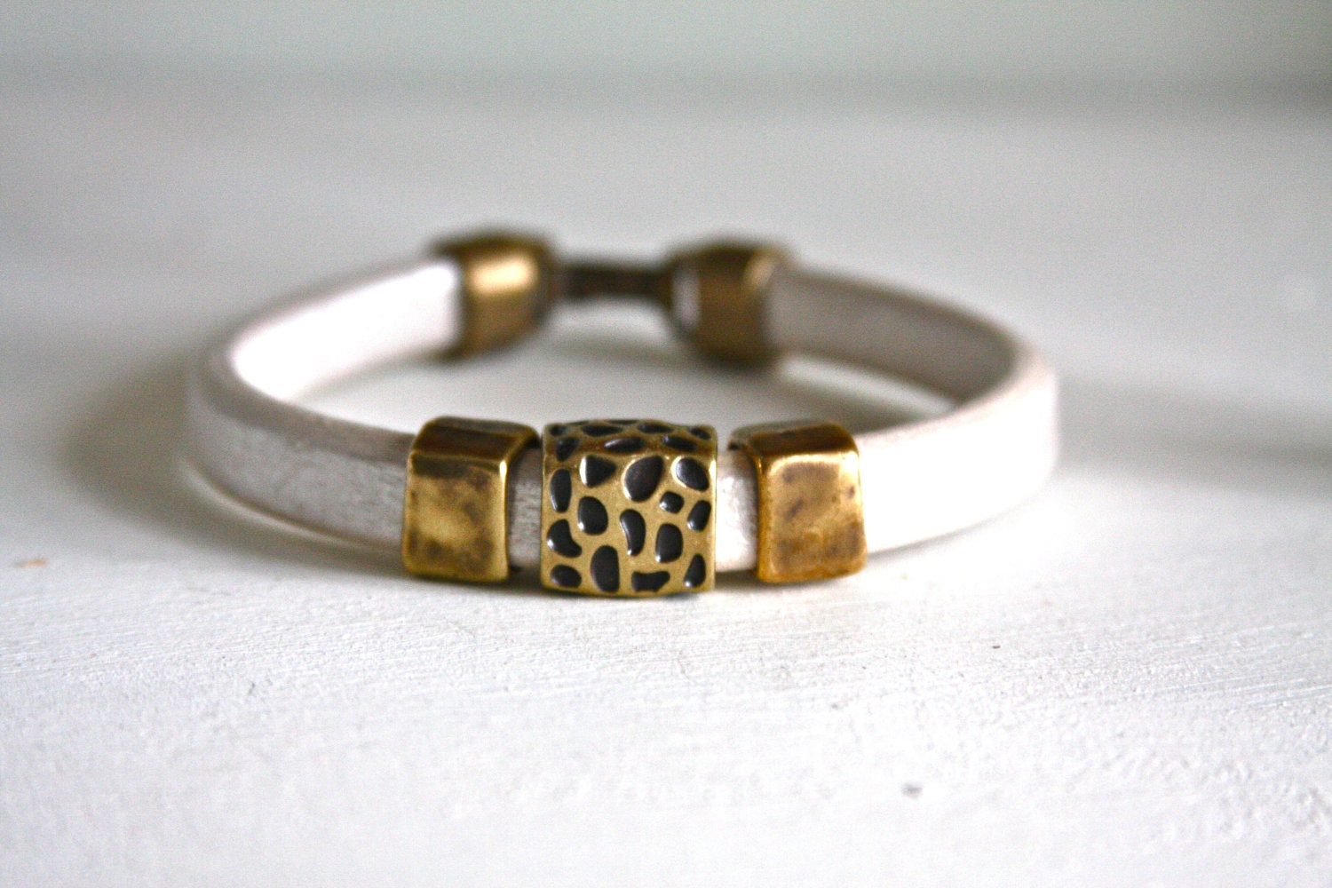 Regaliz leather bracelet in pearl white with antique bronze animal pattern slide beads and antique bronze clasp