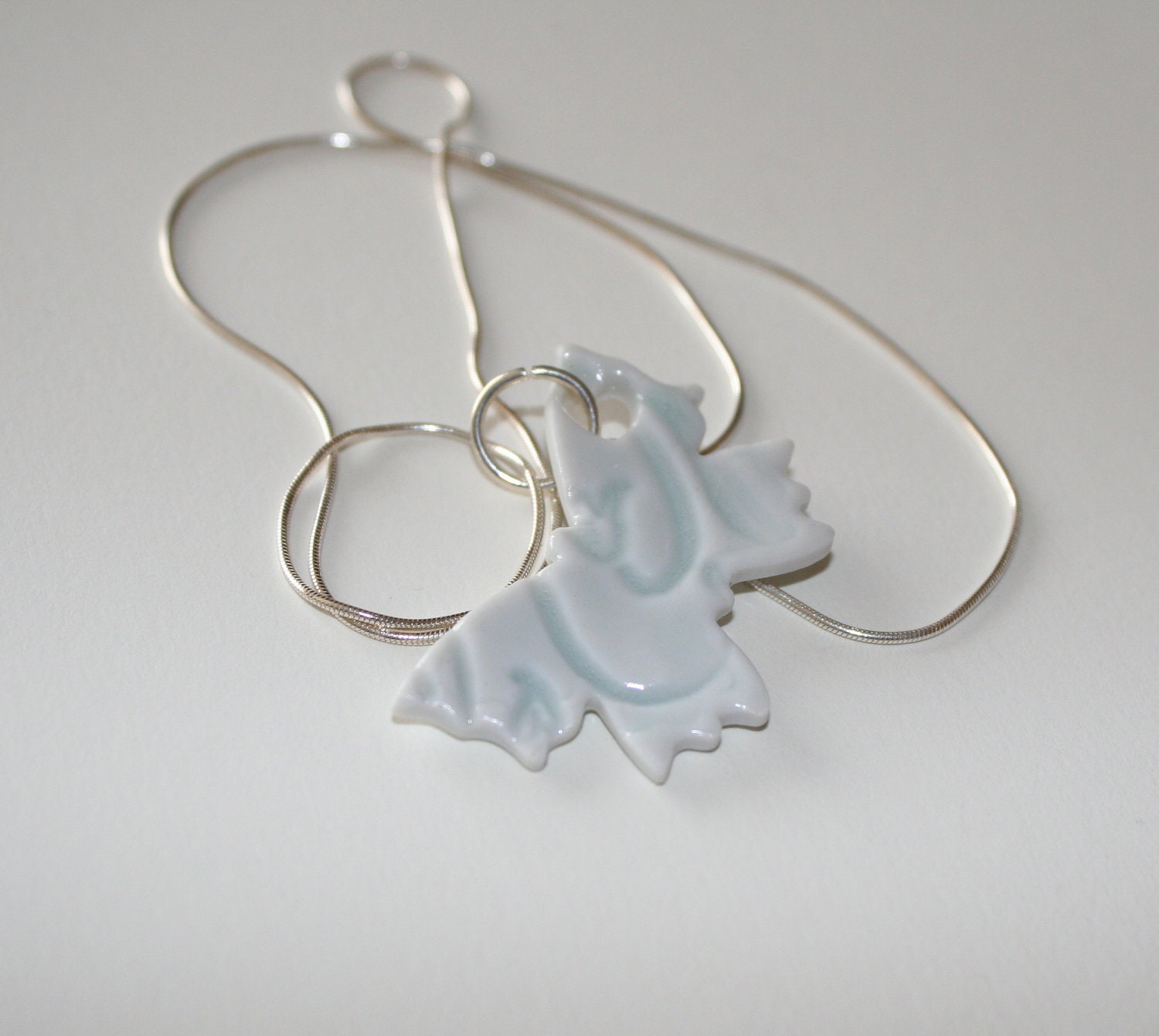 Butterfly porcelain pendant, pale green celadon glaze, impressed design