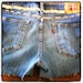 STUDDED and SPIKED Distressed Mid to High Waisted Faded Blue Denim Jean Shorts with Orange Stitching Pink Levis Patch Font Size 9S