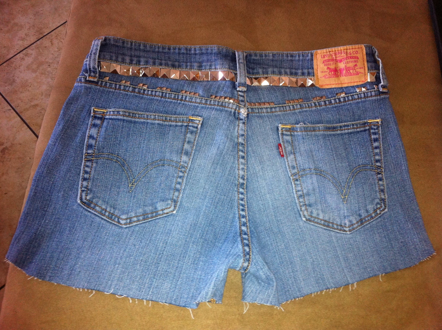 STUDDED and SPIKED Distressed Mid to High Waisted Faded Blue Denim Jean Shorts with Orange Stitching Pink Levis Patch Font Size 9S