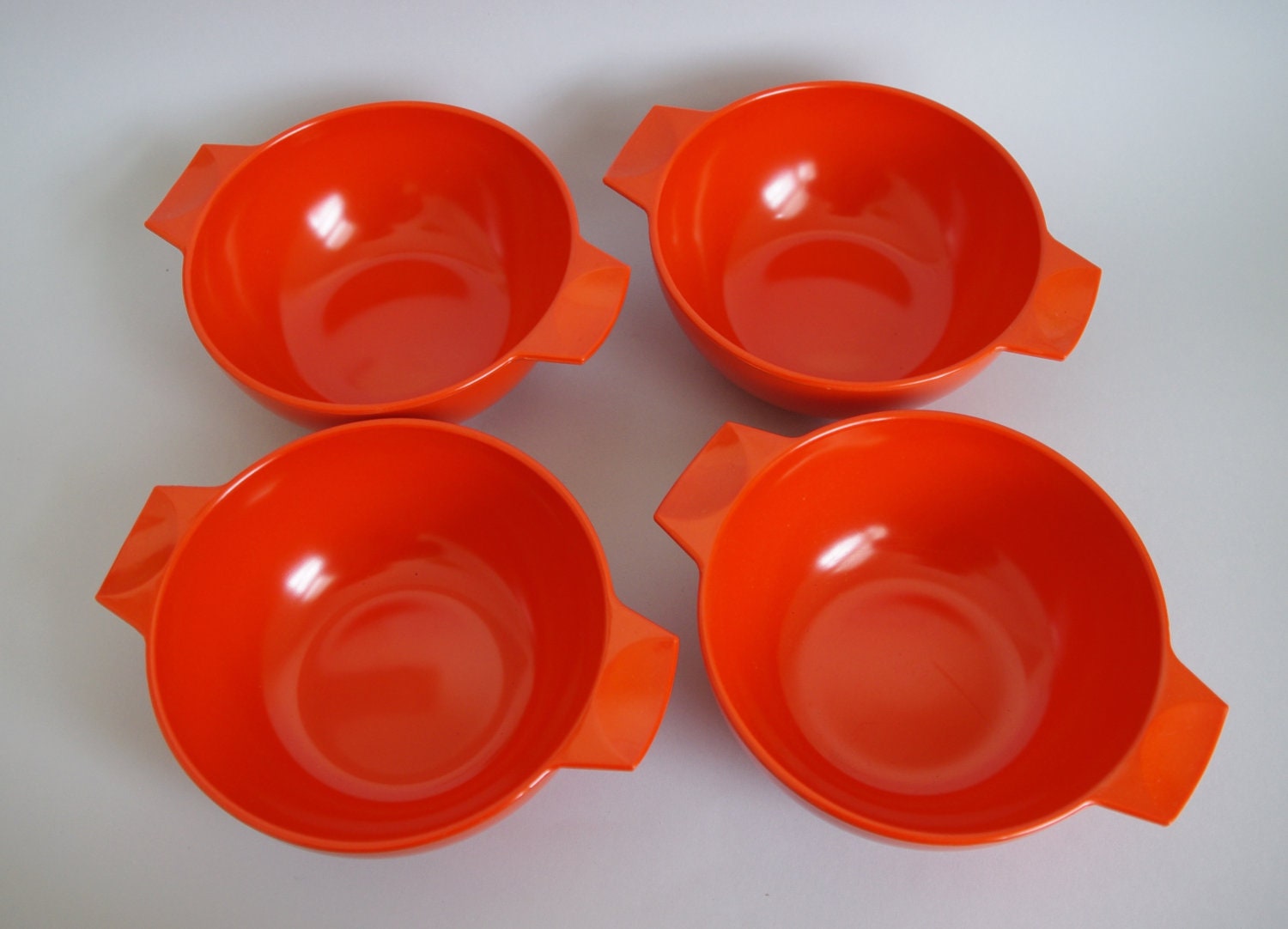 Set of four c1970s hot orange melamine bowls. Melaware, England - TheBestNestCo