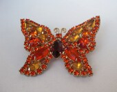 Charming Vintage 1950s-60s butterfly motif brooch with tangerine rhinestones surrounding single amber rhinestone