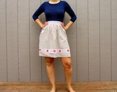 Cute tan and white plaid skirt apron with red flower details and white embroidery