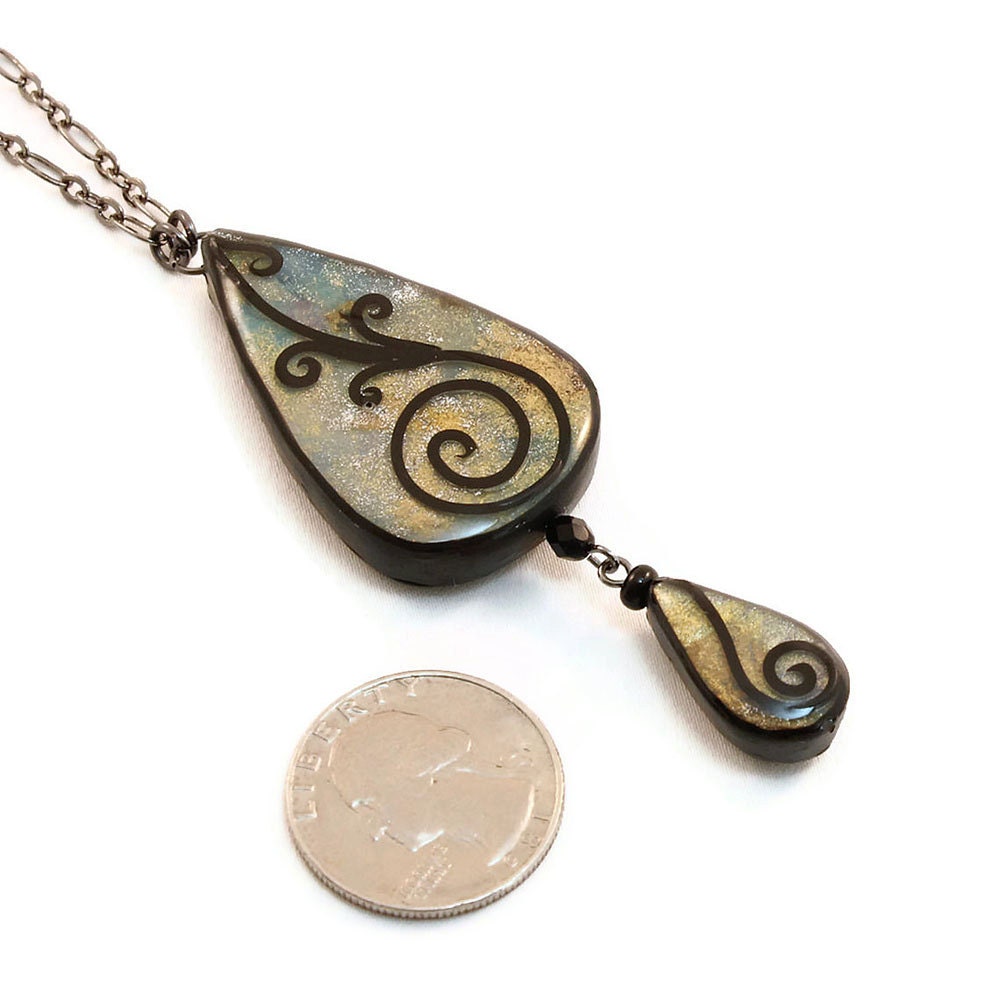 Teardrop necklace in shades of blue and gold with spiral design
