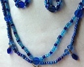 Blue scalloped beaded necklace with tiny filled glass bottle