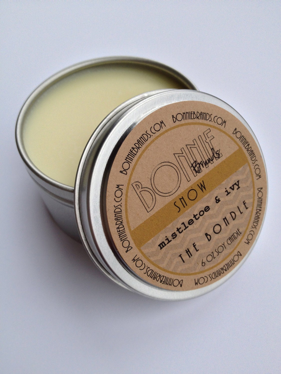 The Bondle: 6 oz Snow Christmas Soy Candle flavored with Mistletoe & Ivy in a Seamless Travel Tin