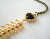 Gold fishbone chain and box chain statement necklace. Black teardrop gold framed connectors.