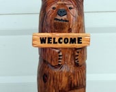 bear chainsaw carving holding sign