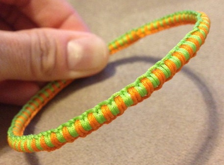 Macramé bangle - lime green and bright orange cord over metal bangle