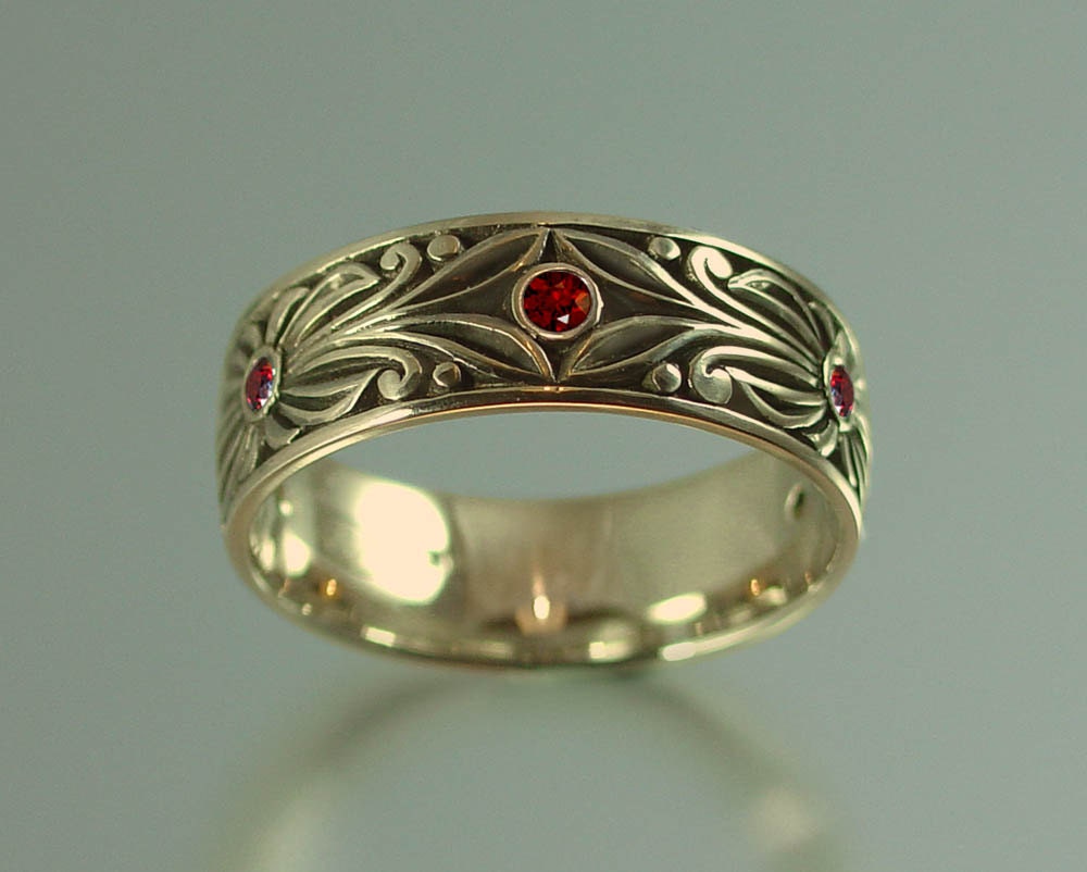 The RED COUNT wedding band in 14K yellow gold with garnet accents