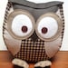 Chubby owl pillow in shades of neutral beige and brown.