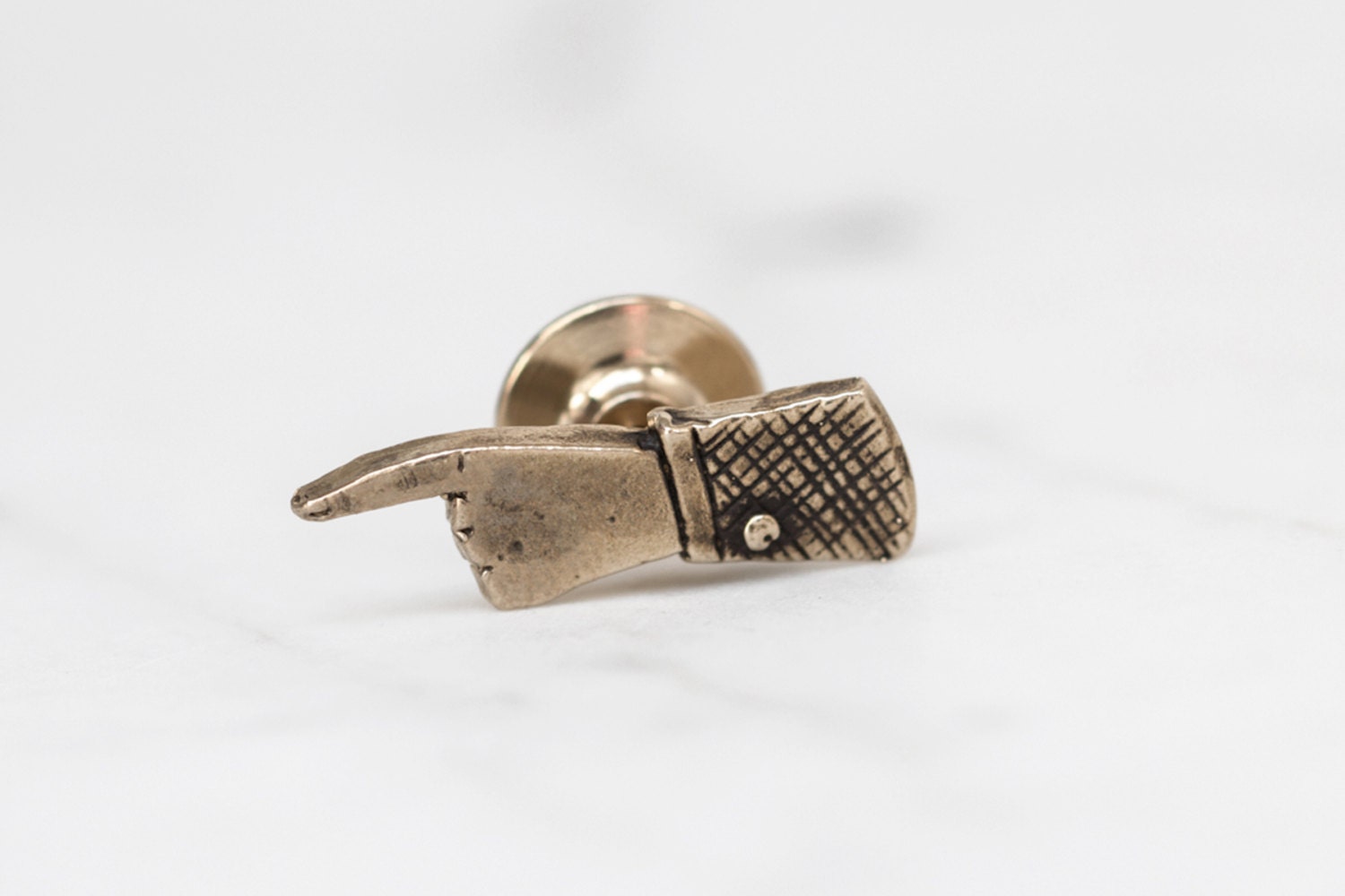 Pointing hand brass lapel pin