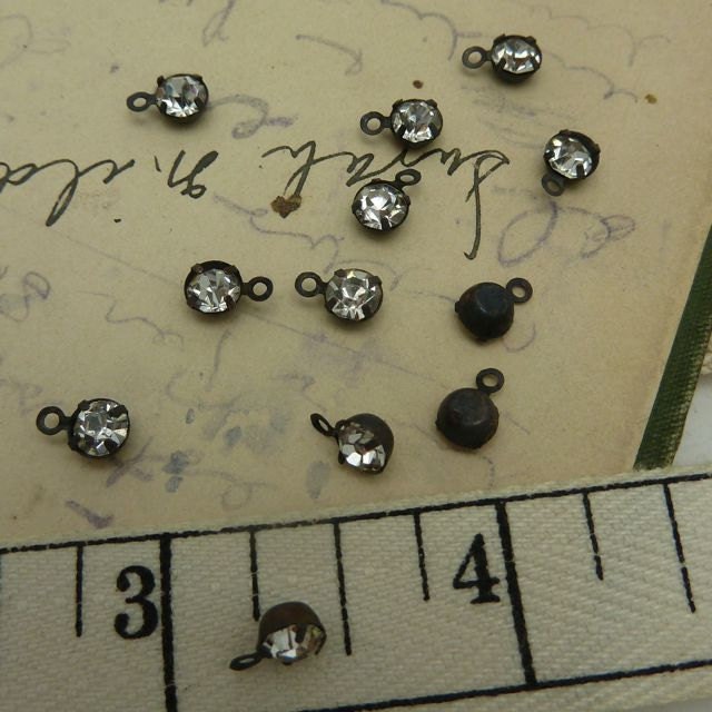 10 4.5 mm facet set rhinestone drops in aged  brass settings with single  loop hanger.