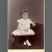 Cabinet Card of a Doll-Like Child in White