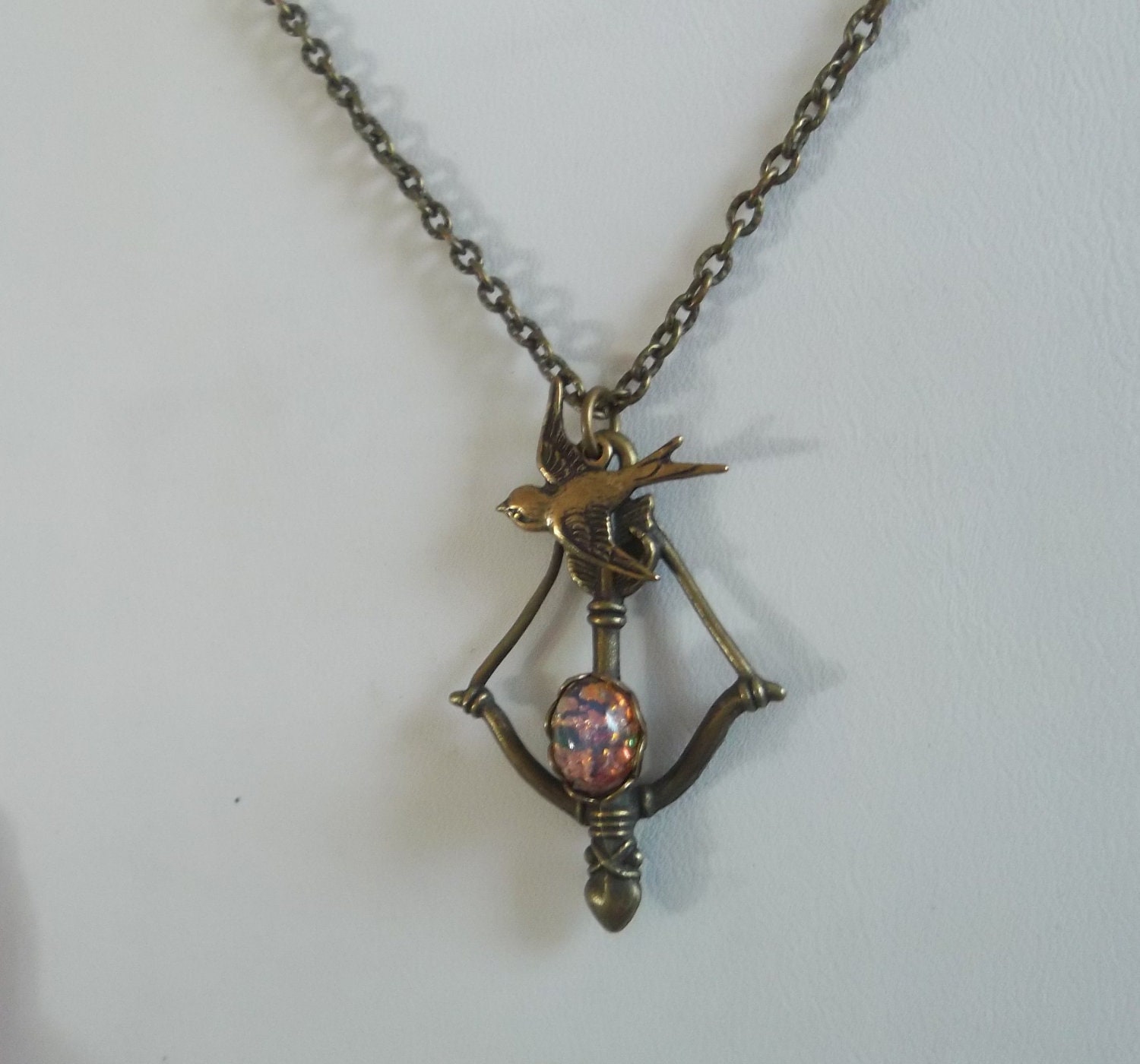 Hunger Games Girl on Fire Katniss Bow and Arrow Mockingjay Necklace with Fire Opal Cabochon Peetas Pearl Catching Fire