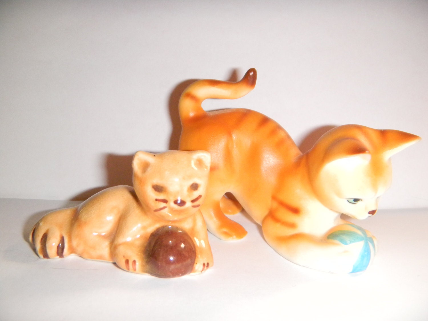 Cute vintage pair of cat figurines with balls..one tan pottery, one orange tiger striped
