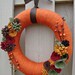 Burnt orange yarn wrapped wreath sage green, maroon, brown and gold