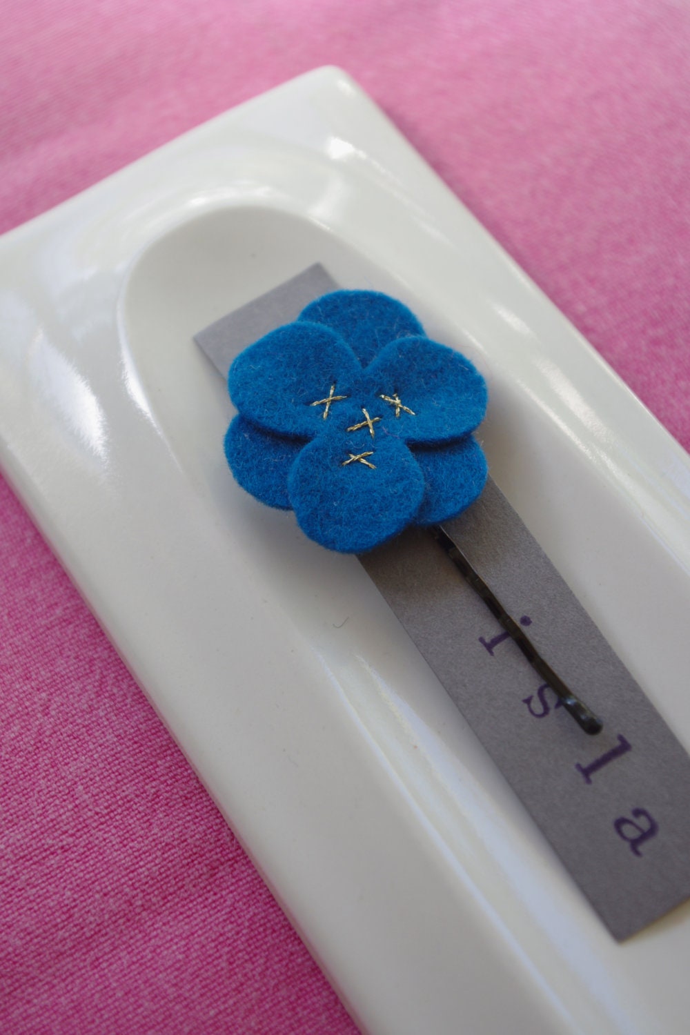 Blue wool felt flower hair clip with gold stitching