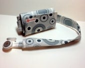 TuneTube.  iPhone/iPod headphone/ear bud cord organizer.  Gray circles.