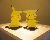 A Set Of Two Origami Pikachus On Black Base Board