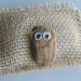 Real Pet Rock wearing glasses funny smile and burlap stuffed bed